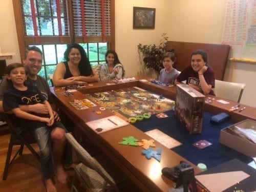 A family playing Scythe around a Tablezilla gaming table